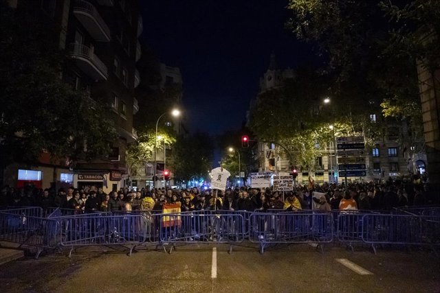 Decenas de personas tras las vallas con carteles y banderas de España, durante una manifestación contra la amnistía frente a la sede del PSOE en Ferraz, a 17 de noviembre de 2023, en Madrid (España). 