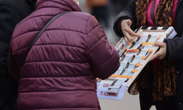Archivo - Una mujer compra un décimo de lotería a una vendedora ambulante, tres días antes del Sorteo de La Lotería del Niño, a 3 de enero de 2022, en Madrid, (España). 