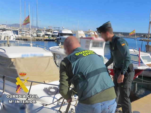 Agentes de la Guardia Civil con una de las embarcaciones ilegales decomisadas