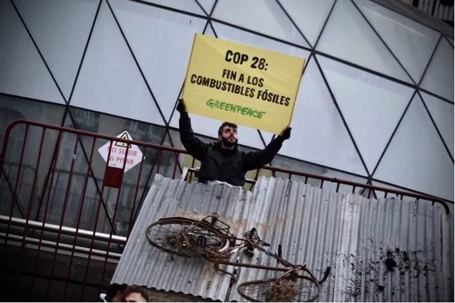 Un activista de Greenpeace sostiene un pancarta durante la acción protagonizada por Greenpeace en la Puerta del Sol.