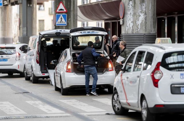 Archivo - Varias personas cogen un taxi en el exterior de la estación Puerta de Atocha-Almudena Grandes, a 7 de febrero de 2023. Archivo.