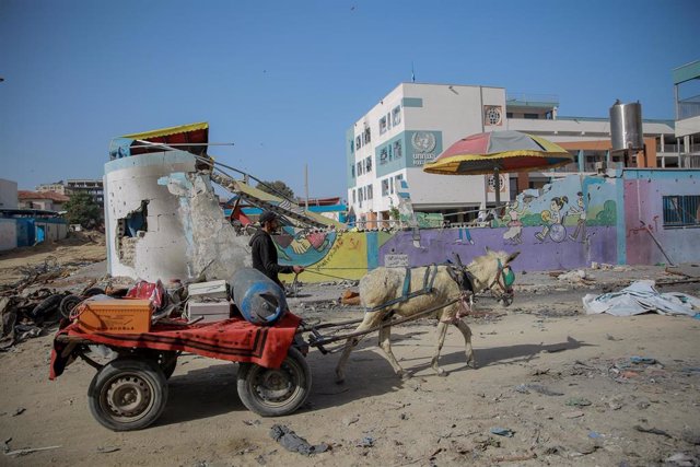 Un palestino pasa ante una escuela de la UNRWA destruida en la capital de la Franja de Gaza