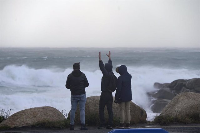 Archivo - Tres jóvenes miran y fotografían el mar embravecido, a 4 de noviembre de 2023, en A Coruña, Galicia (España).