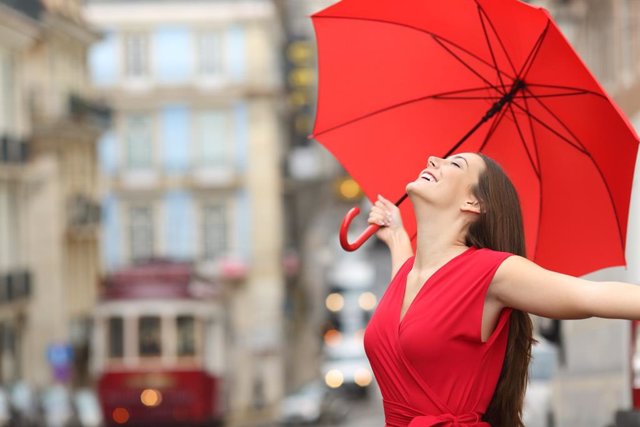 Archivo - Mujer feliz en la calle con paraguas 