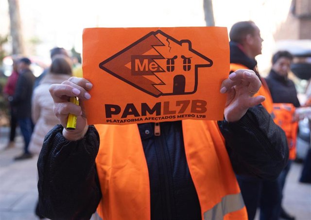 Archivo - Una mujer porta una pancarta de la Plataforma de Afectados Metro L7B 