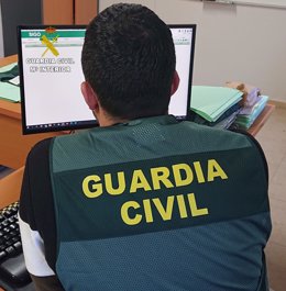 Archivo - Un agente de la Guardia Civil mira la pantalla de un ordenador, en imagen de archivo