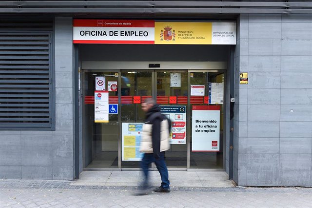 Archivo - Una persona pasa al lado de una oficina de empleo