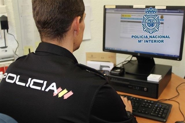 Archivo - Agente de la Policía Nacional frente a un ordenador.