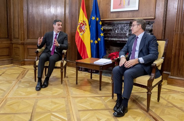 El presidente del Gobierno, Pedro Sánchez (i), y el líder del PP, Alberto Núñez Feijóo (d), conversan durante una reunión, en el Congreso de los Diputados