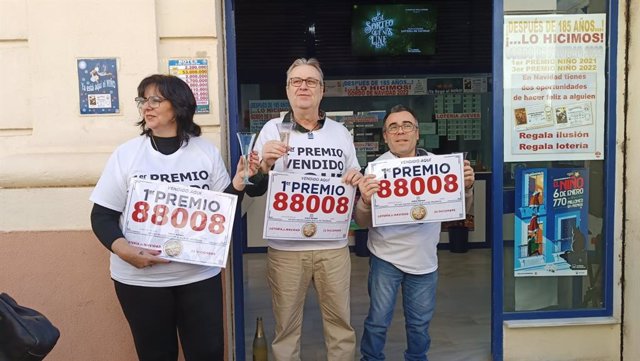 Los loteros de la administración El Paraíso de Jerez con el cartel del Gordo de Navidad.