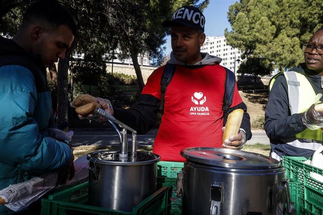 Un voluntario de Ayuda una Familia durante el reparto de alimentos a personas sin recursos en el viejo cauce del Turia, en València. 