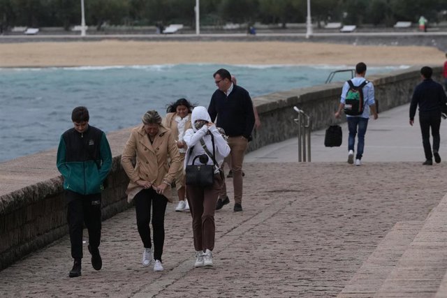 Archivo - Varias personas caminan bajo la lluvia en la playa de Ondarreta, a 14 de octubre de 2023, en San Sebastián, Guipúzcoa, País Vasco (España). 
