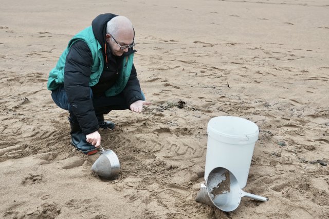 Un voluntario recoge pellets en la playa de La Arena, a 10 de enero de 2024, en Muskiz, Vizcaya, País Vasco (España)