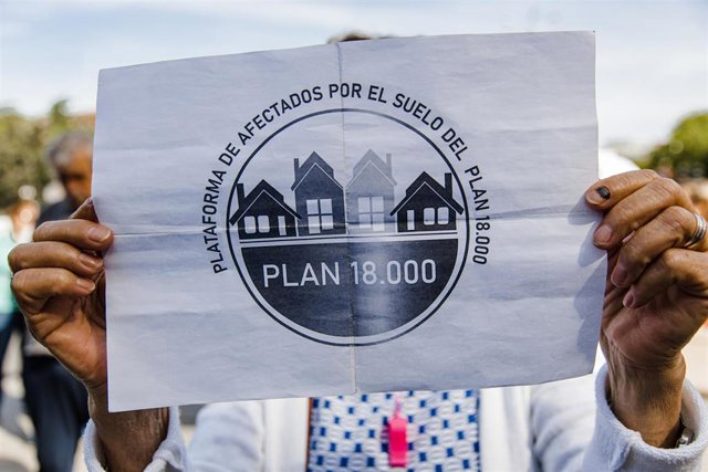 Archivo - Una persona sujeta una pancarta durante una protesta sobre el Plan 18000 Venta de Suelo, frente a las puertas del Ayuntamiento, a 25 de abril de 2023, en Madrid (España).  Con la descalificación del suelo, el precio en el último pliego se ha mul
