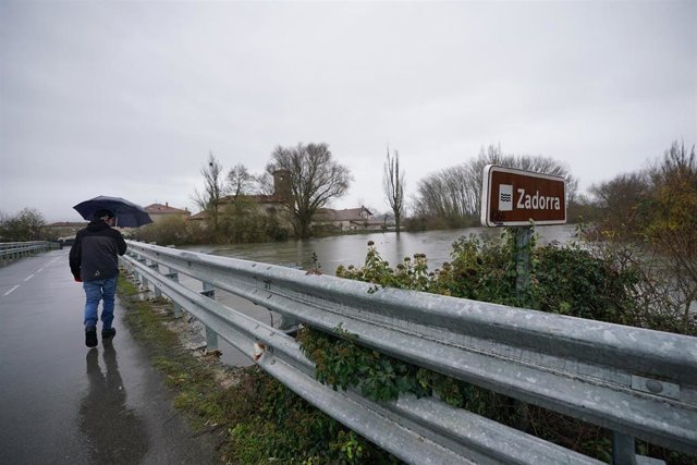 Archivo - Una persona pasa al lado del río Zadorra, 
