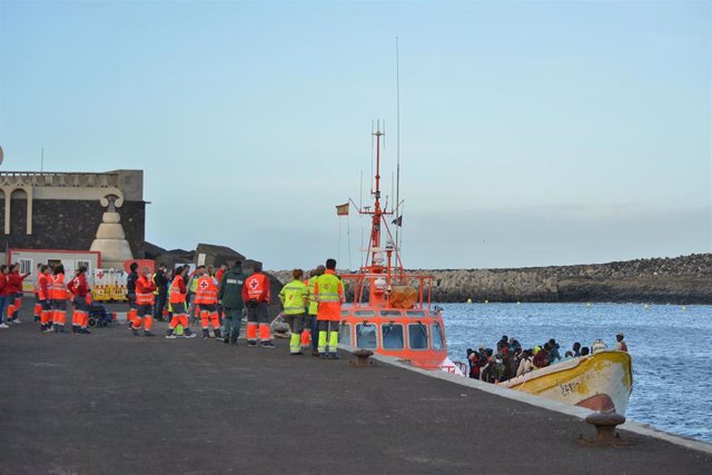 Archivo - Trabajadores de la Cruz Roja esperan la llegada de una patera que llega al Muelle de La Restinga.