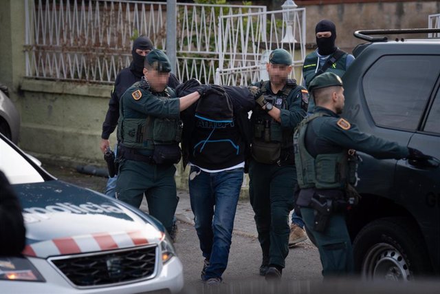 Varios agentes de la Guardia Civil llevan a un detenido tras una operación policial antiyihadista en una vivienda, a 16 de enero de 2024, en Martorell, Barcelona, Catalunya (España). 