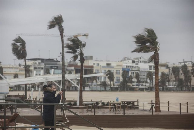 Archivo - Dos personas caminan en la Playa de la Malvarrosa, a 25 de marzo de 2022, en Valencia, Comunidad Valenciana (España). Tras once días de temporal de lluvia, el litoral de la provincia de Valencia permanece durante el día de hoy en alerta nivel am
