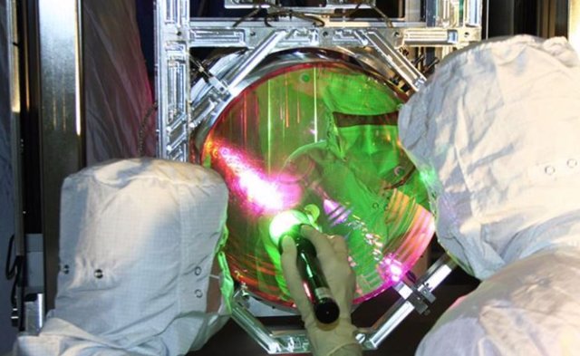 Los técnicos inspeccionan el revestimiento de "primer contacto" en una de las masas de prueba de entrada (espejos) de LIGO.