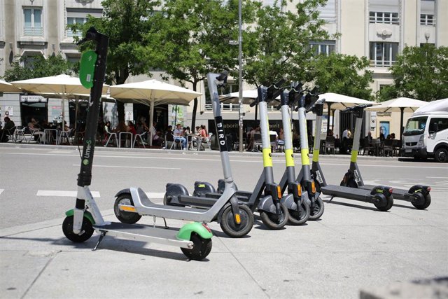 Archivo - Varios patinetes estacionados en una calle céntrica de Madrid