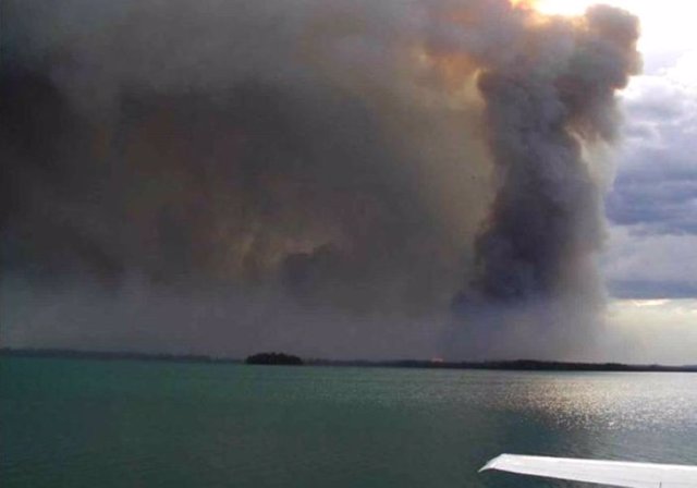 Foto de un incendio con el mar en primer plano.