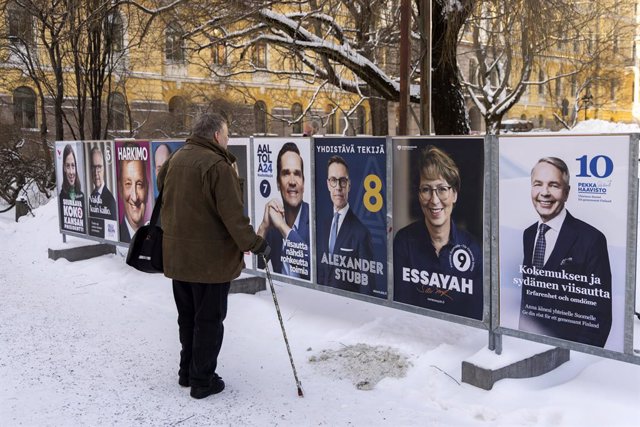 Ciutadà finlandès davant de cartells electorals dels candidats a la Presidència de Finlàndia