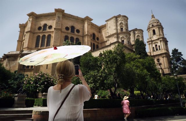 Archivo - Una señora con un paraguas fotografía la Catedral en una imagen de archivo 