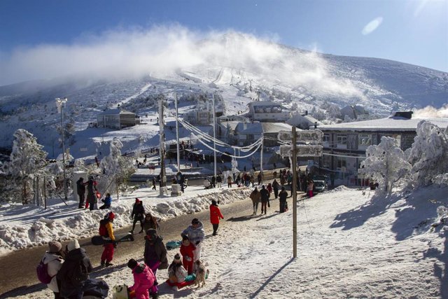 Archivo - Varias personas disfrutan de la nieve en la estación de esquí de Puerto de Navacerrada.