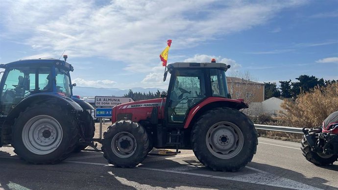 Tractores en la carretera delante de un cartel indicativo de La Almunia