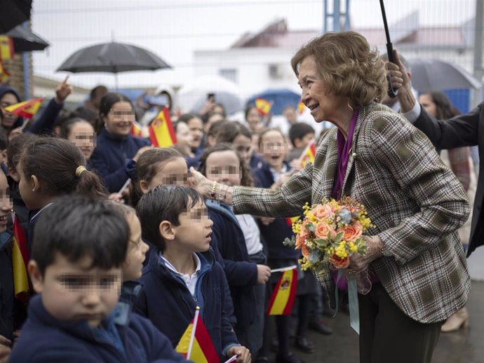 La reina Sofía saluda a niños que la esperan antes de su visita al Banco de Alimentos en Huelva