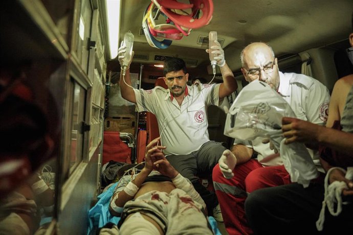 Archivo - Imagen de archivo de trabajadores sanitarios con un herido de camino al hospital de Al Amal, en Jan Yunis (Gaza)