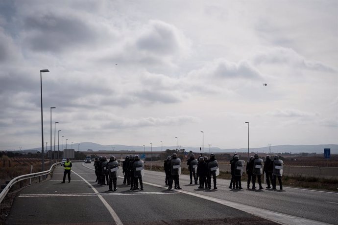 Varios antidisturbios acuden a una carretera cortada por decenas de agricultores durante la tercera jornada de protestas de los ganaderos y agricultores para pedir mejoras en el sector, en la autovía A-3, a 8 de febrero de 2024, en Valencia, Comunidad Val