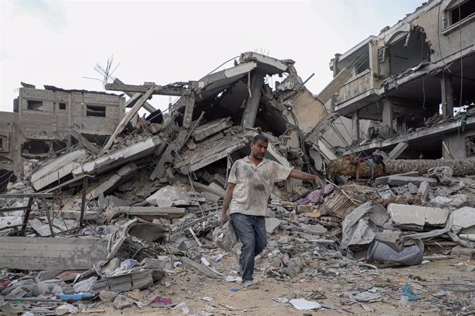 Archivo - Un palestino junto a edificios destruidos por los bombardeos del Ejército de Israel contra Jan Yunis, en el sur de la Franja de Gaza (archivo)
