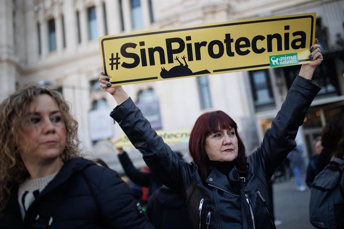 Una mujer protesta con un cartel durante una manifestación contra el uso de la pirotecnia, en la Plaza de Cibeles, a 17 de febrero de 2024, en Madrid (España). 