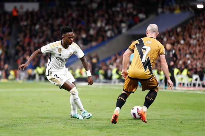 Archivo - El delantero del Real Madrid Vinícius Júnior regatea al jugador del Rayo Vallecano Isi Palazón, en el duelo disputado enel Santiago Bernabéu de LaLiga EA Sports 2023-2024.